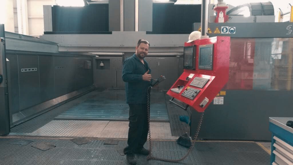 Ferramenteiro da Gold Hands ao lado de um centro de usinagem